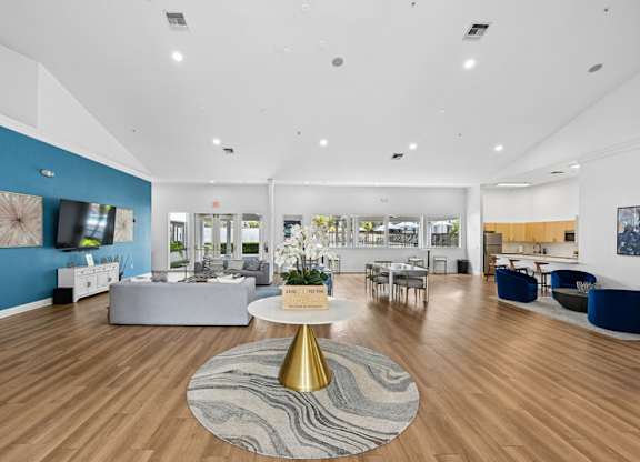 A spacious room with a round rug and a golden table in the middle.