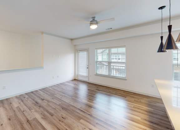 A room with wooden flooring and a ceiling fan.