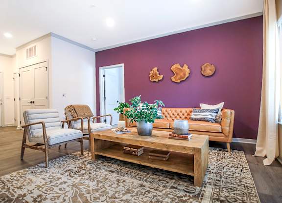 A living room with a purple wall and a wooden coffee table.