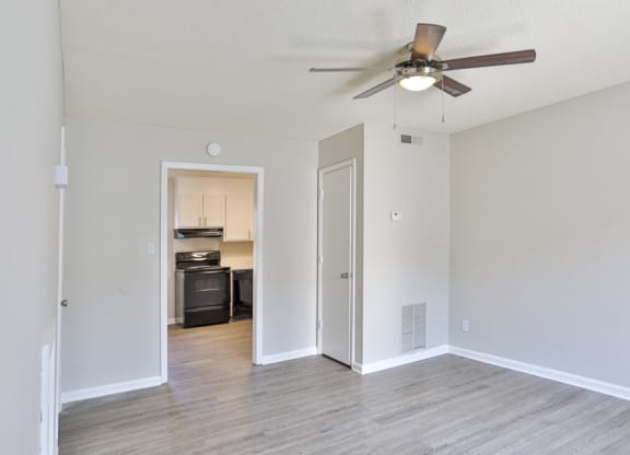 an empty room with a large window and hardwood floors
