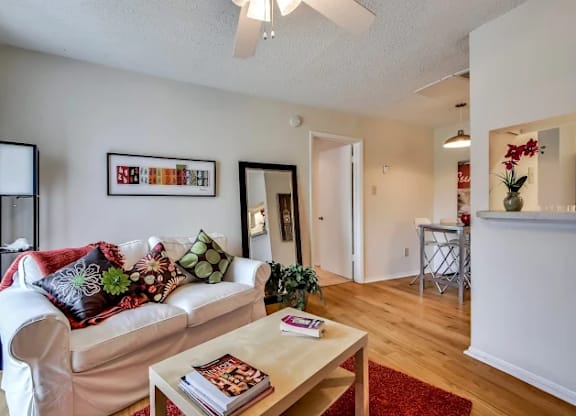 A living room with a white couch and a coffee table.
