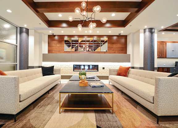 A modern living room with a glass coffee table and two couches.