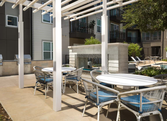 a patio with tables and chairs and a fire place