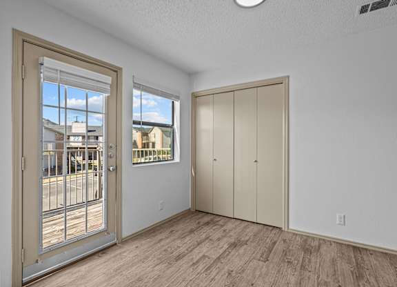 A room with a door, a window, and a wall-mounted cabinet.