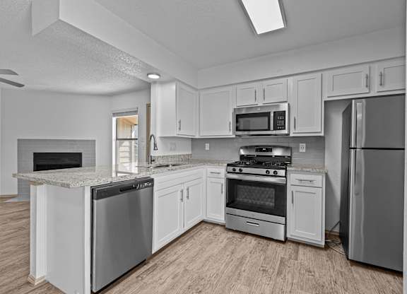 A kitchen with white cabinets and stainless steel appliances.