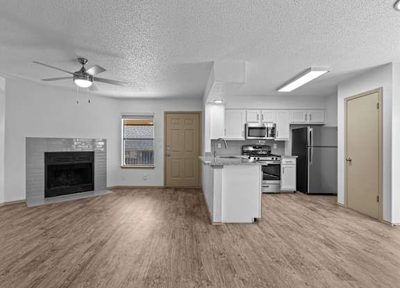 A spacious kitchen with a fireplace and a refrigerator.
