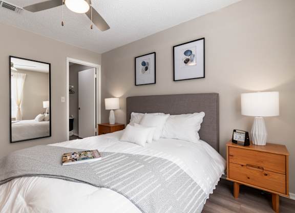 A bedroom with a large bed and a ceiling fan.