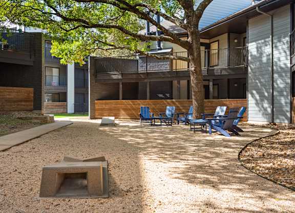 a fire pit and chairs in the courtyard of a building