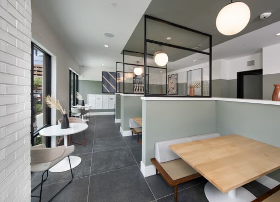 a dining area with a wooden table and chairs and a glass partition