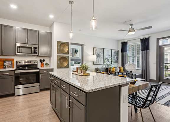 A modern kitchen with a large island and stainless steel appliances.