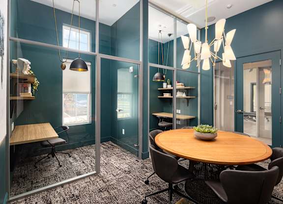 A modern dining room with a round wooden table and chairs.