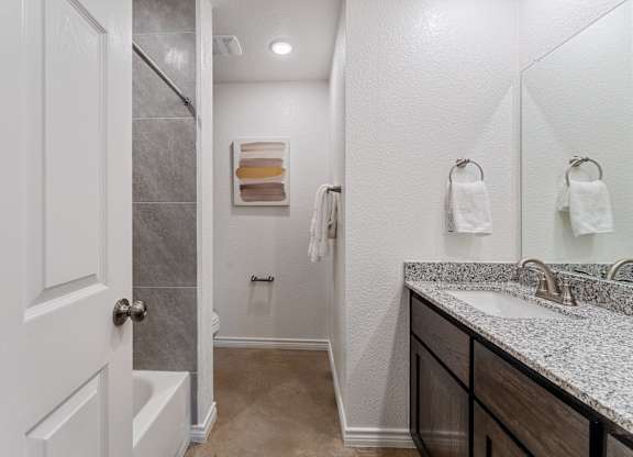 a bathroom with a shower and a sink and a mirror