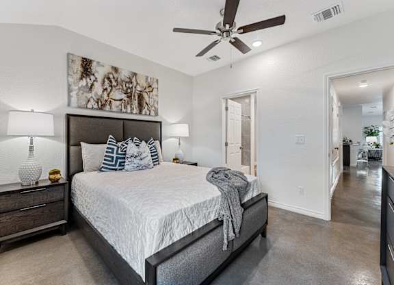 a bedroom with a large bed and a ceiling fan