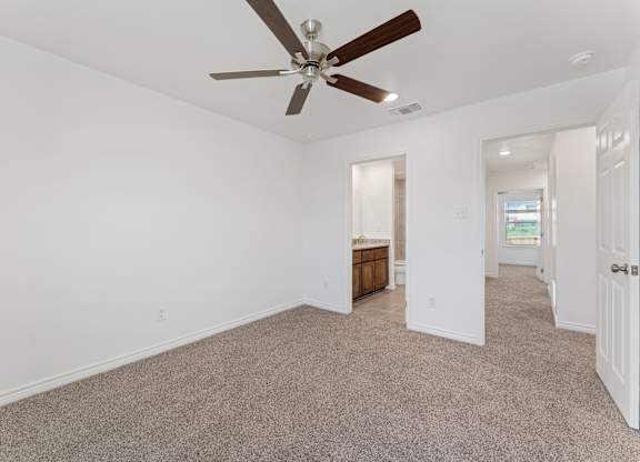 an empty living room with a ceiling fan and white walls