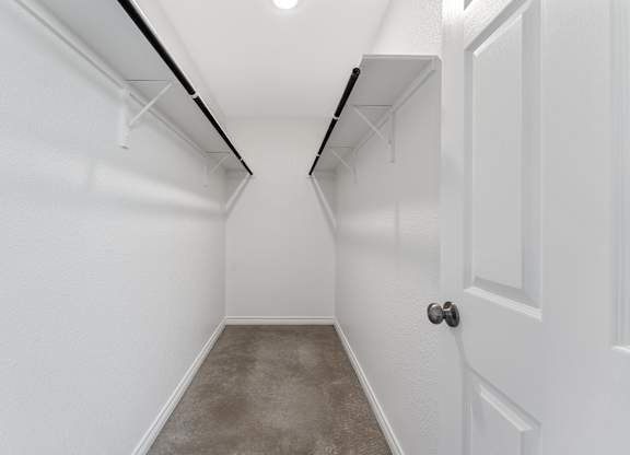 an empty room with white walls and a concrete floor and a white door