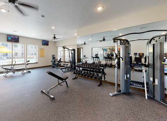 A spacious gym with a variety of equipment including treadmills, weights, and exercise machines.