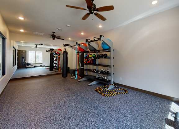 A room with a ceiling fan and a grey carpet.