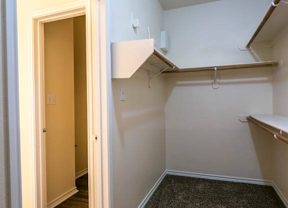 A hallway with a carpeted floor and a white door.