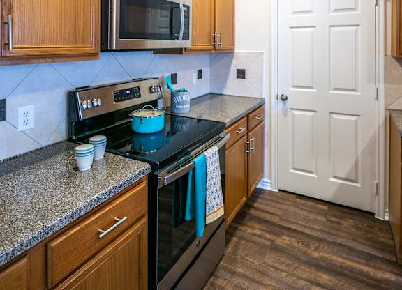 A kitchen with wooden cabinets and a black stove top.