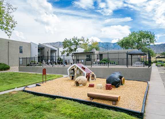 A playground with a sandbox and a bench.