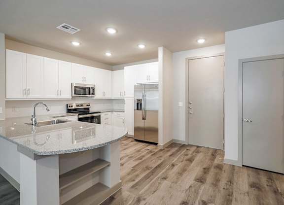 A kitchen with a sink, microwave, and refrigerator.