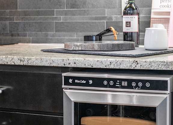 A kitchen with a wine bottle and a sign that says