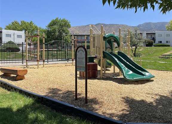 a playground with a slide and a picnic table