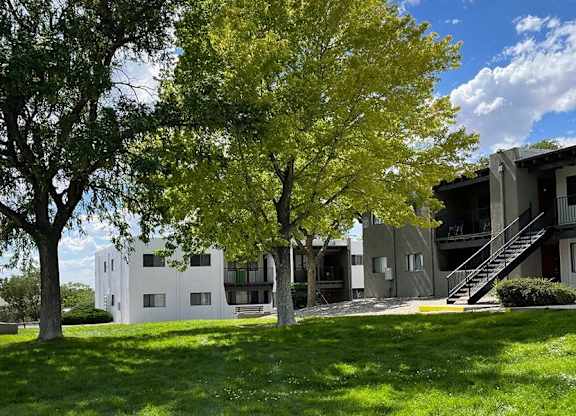 a building with a staircase and trees in front of it