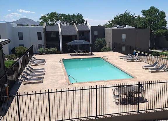 a pool with a fence around it and a building in the background