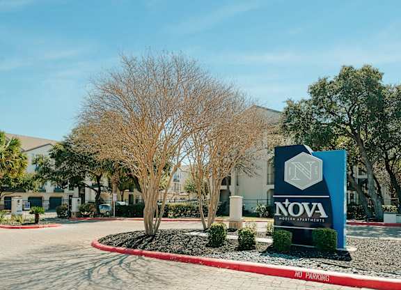 A sign for Nova Gris Partners stands in front of a building.