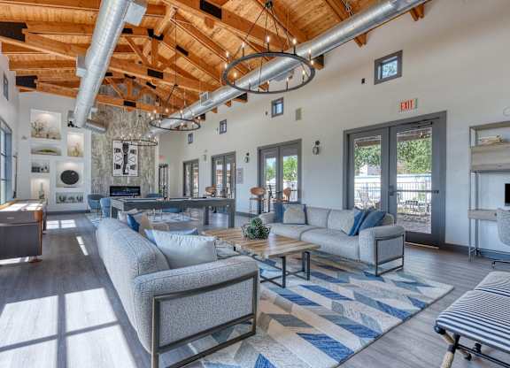 A living room with a grey couch and a blue and white rug.