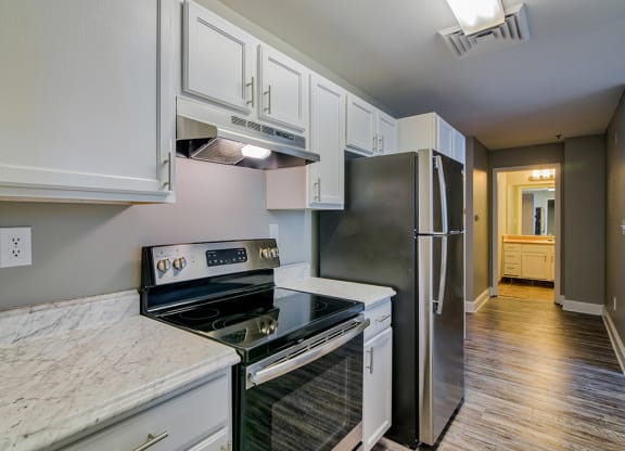 a kitchen with white cabinets and stainless steel appliances