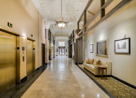 a large hallway with a chandelier and a couch