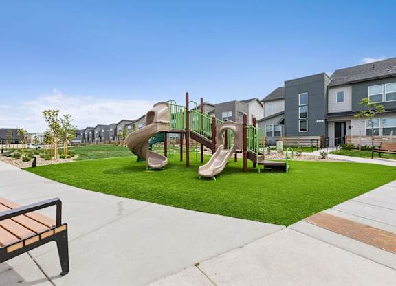 A playground with a slide and a bench.
