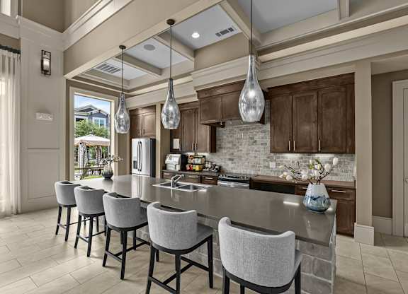 A kitchen with a long island and chairs.