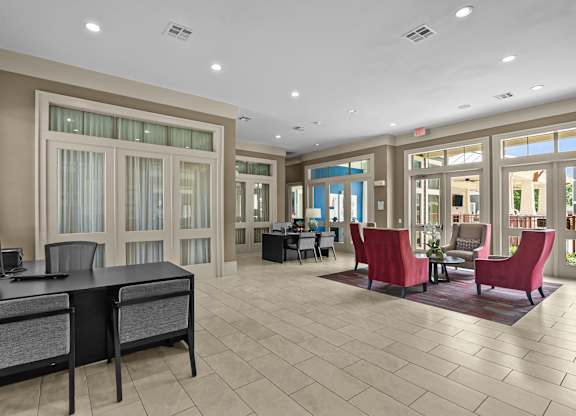 A spacious office with a desk, chairs, and a large window.