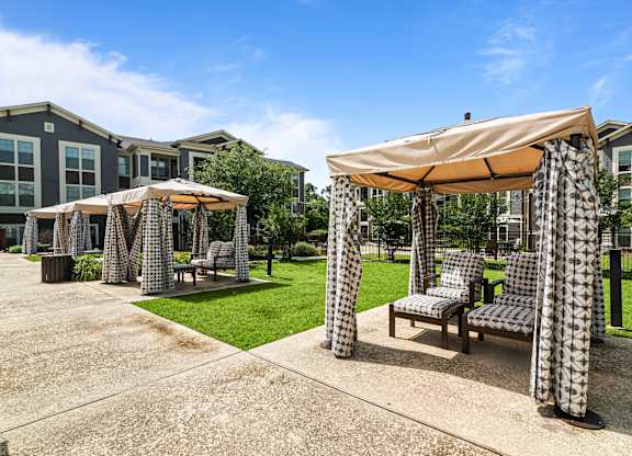 A patio area with a table and chairs under a canopy.