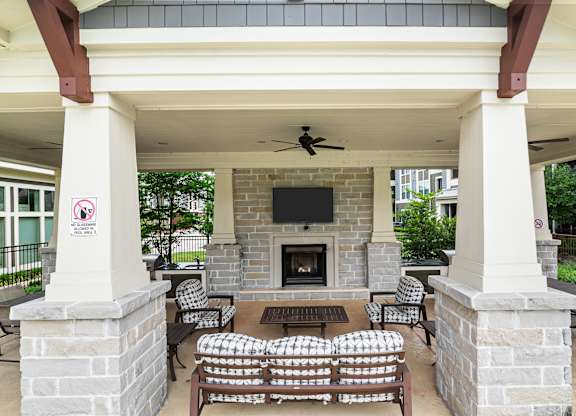 A patio with a fireplace and chairs.