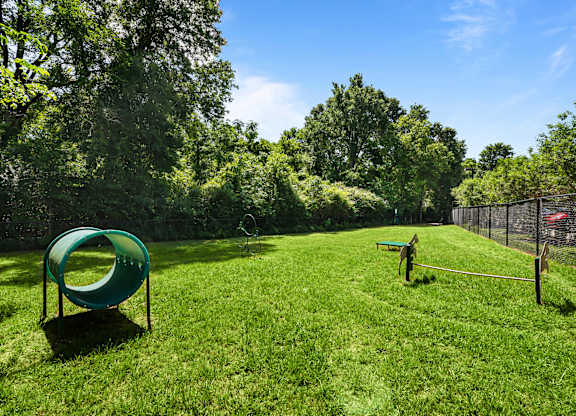 A playground with a green slide and a bench.