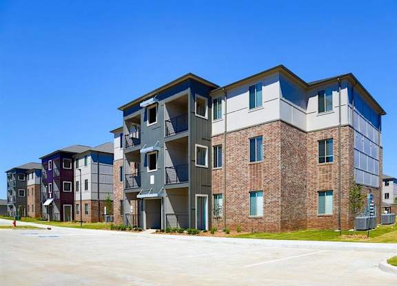 A row of modern apartment buildings with a clear blue sky above.