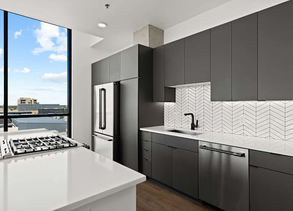 A modern kitchen with a white countertop and black cabinets.