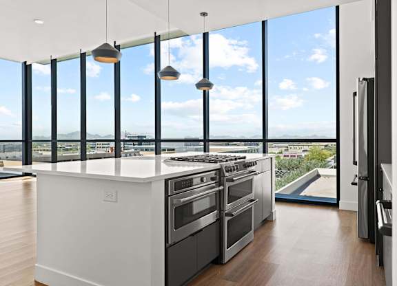 A modern kitchen with a large island and stainless steel appliances.
