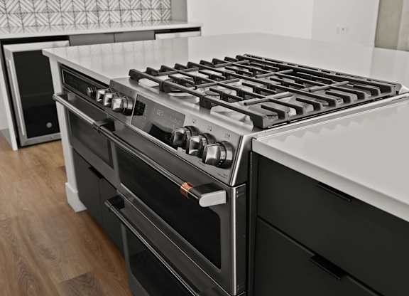 A modern kitchen with a black stove top oven.