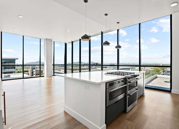 A modern kitchen with a large island and stainless steel appliances.