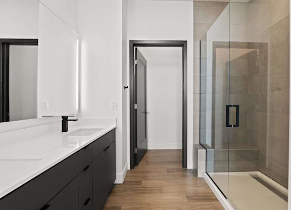 A bathroom with a walk in shower and a sink.