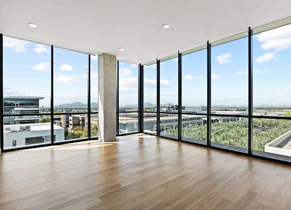 A room with a view of the city through large windows.