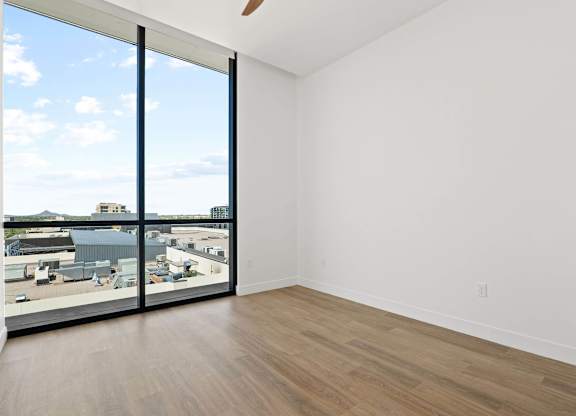 A large empty room with a view of the city.