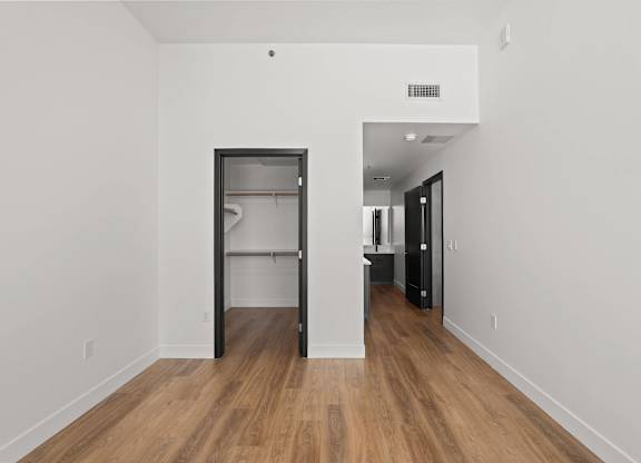 A room with a white wall and a black door.