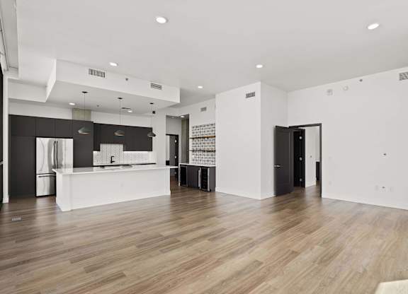 A modern kitchen with a white counter and a black fridge.