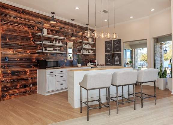 A kitchen with a wooden wall and white countertops.